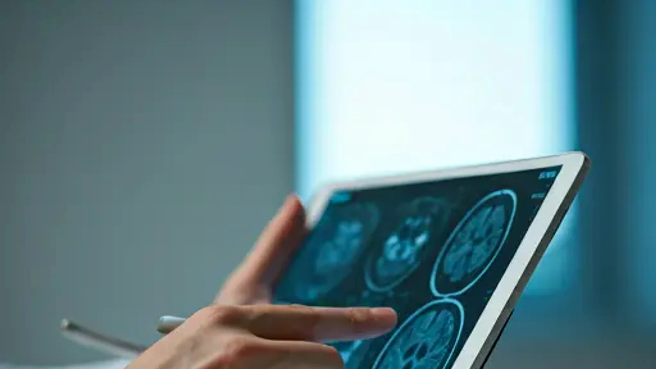 Dokter meninjau pemindaian medis pada tablet di klinik modern.